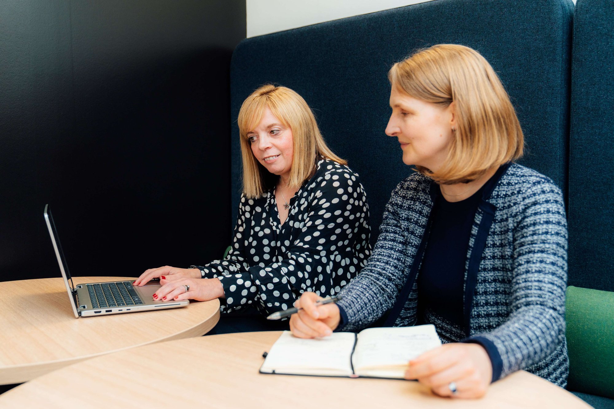 An image of two AAB employees working together on their laptop.