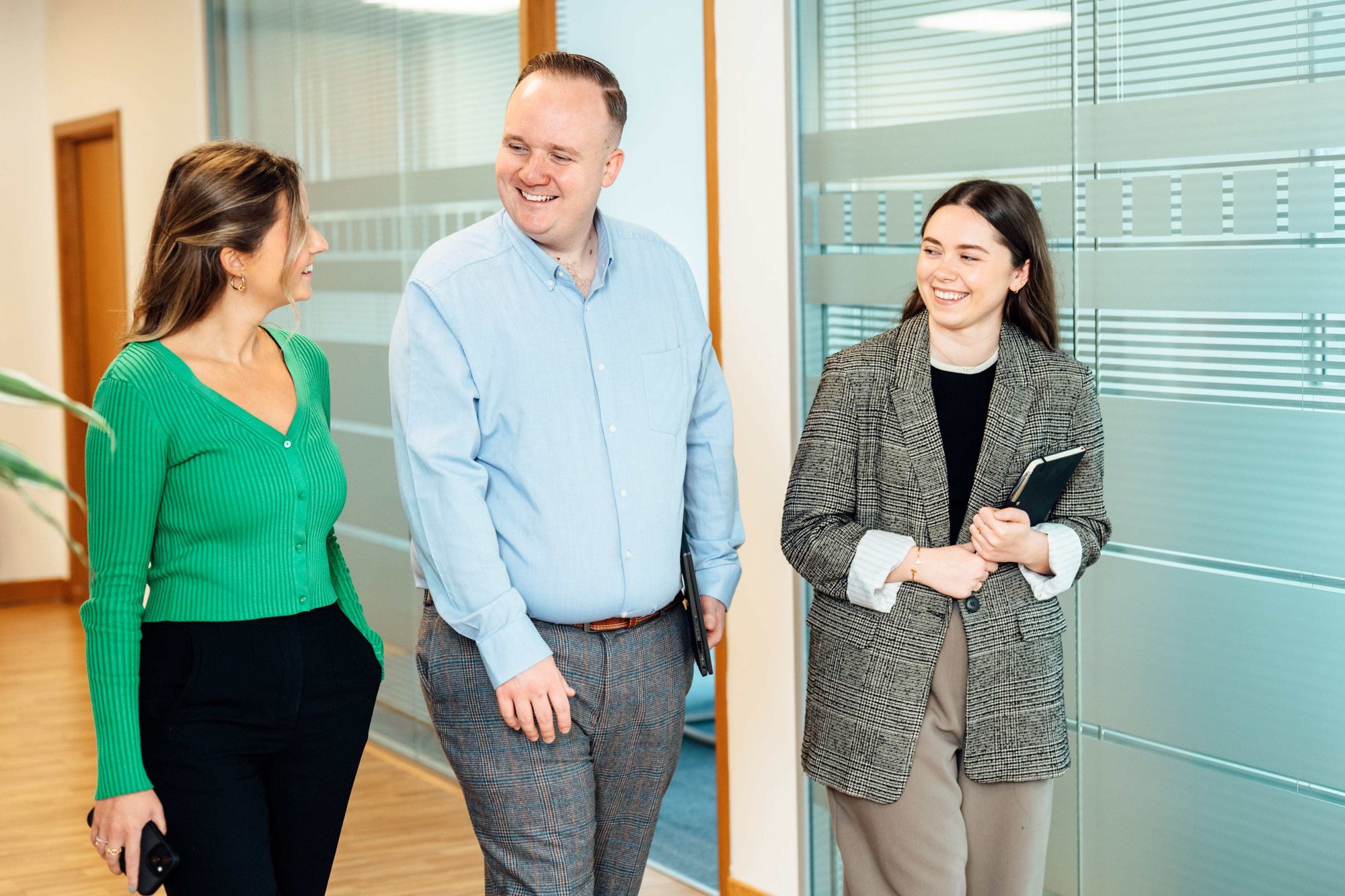 An image of three AAB employees walking in the office and having a conversation.